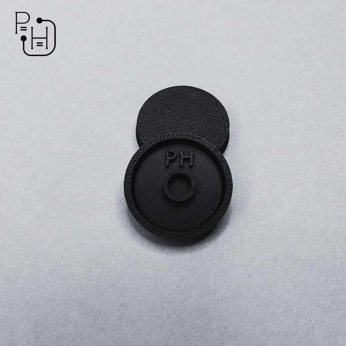 Black 3D printed wargaming base with PH logo, textured surface for miniature models