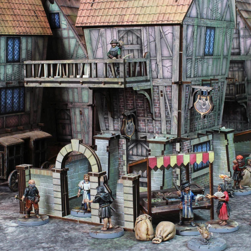 Medieval wargaming scene with detailed buildings, figures, and market stalls for hobby enthusiasts
