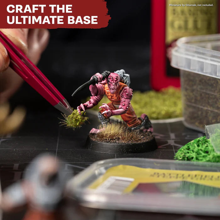 Wargaming miniature base crafting with tweezers and scenic flocking materials for hobbyists