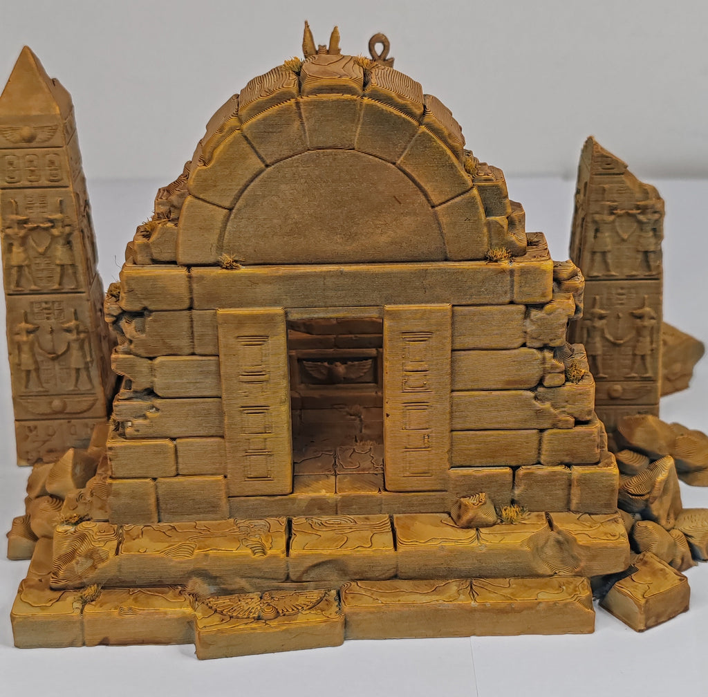 A miniature model of an ancient stone temple or tomb with a domed roof, carved pillars, and detailed hieroglyphic patterns, shown on a plain white background.