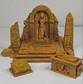 A set of miniature Egyptian-themed toy figurines and structures, including a central Anubis statue in an ancient temple, a sphinx, an obelisk, and a sarcophagus, all in a uniform terracotta clay color.